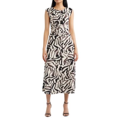 A woman wearing a brown-and-white geometric print dress with black heels