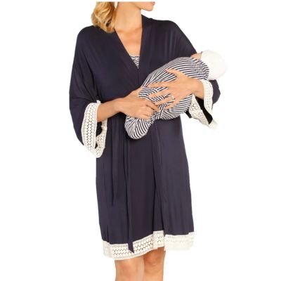 A woman wearing a navy short robe and navy-and-white striped top. She is holding a baby wearing a matching striped blanket and a white hat.
