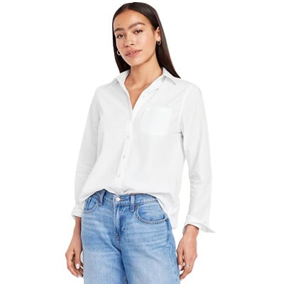 A woman wearing a white button-front shirt and light blue jeans