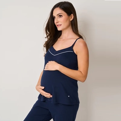 A pregnant woman in a navy pajama set