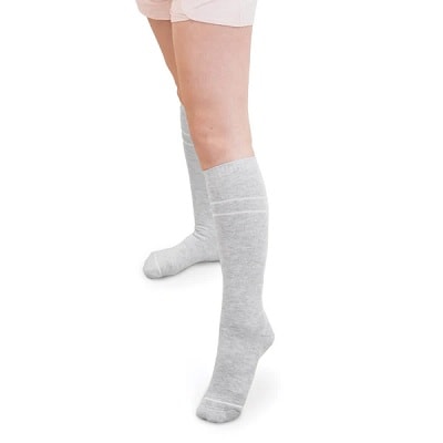 A white woman's legs with gray, knee-high compression socks 