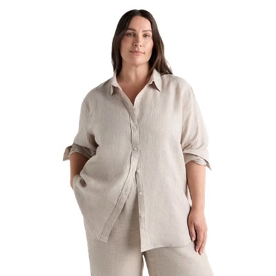 A woman wearing a sand-colored, linen button-front shirt with matching linen pants