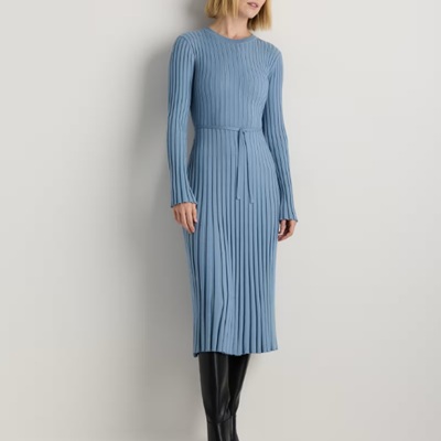 A woman wearing a blue long sleeve ribbed midi dress and black boots