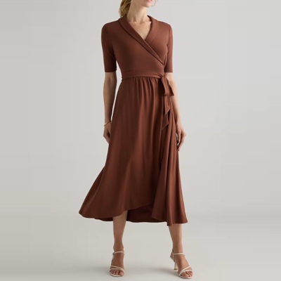 A woman wearing a brown wrap dress with off-white sandals