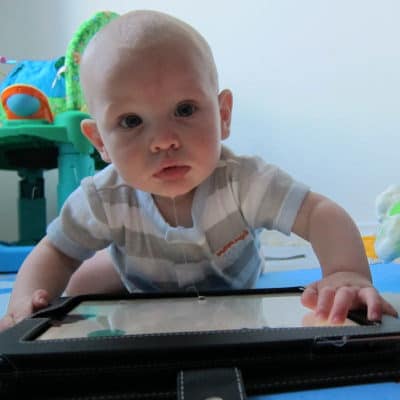 A baby sitting in front of a computer