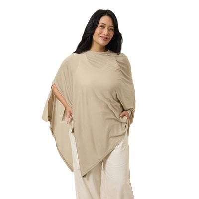 A woman wearing white pants, a tank top, and a large beige nursing cover draped over her body