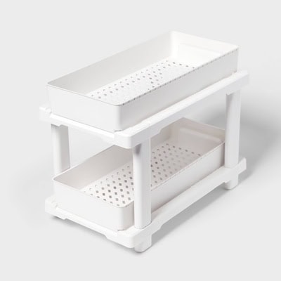 A white plastic under-sink organizer with two shelves