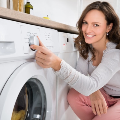 A person sitting in front of a washer