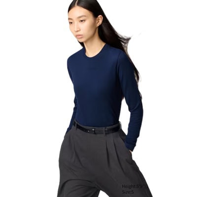 A woman wearing a navy long-sleeved underlayer and dark gray pants