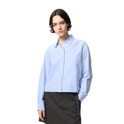 A woman wearing a light blue Oxford and black skirt