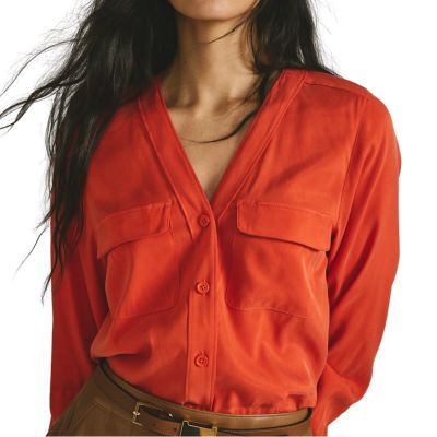 A woman wearing a bright orange top (only torso shown)