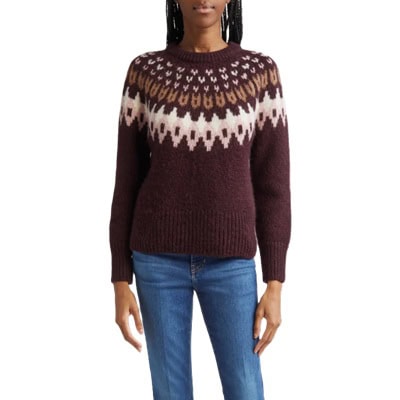 A woman wearing blue jeans and a brown Fair Isle sweater