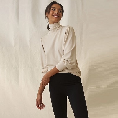 A lady wearing a white turtleneck top