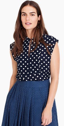 A woman wearing a Drapey Cap Sleeve Top in Polka Dot