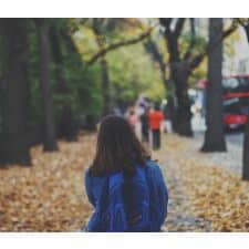 A girl walking during fall.