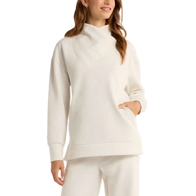 A woman wearing an off-white tunic top and matching sweatpants