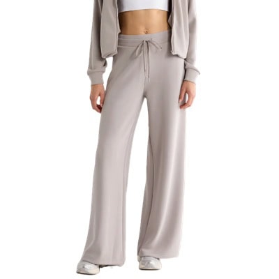 A woman wearing a white cropped tee, gray wide-leg pants and a gray hoodie