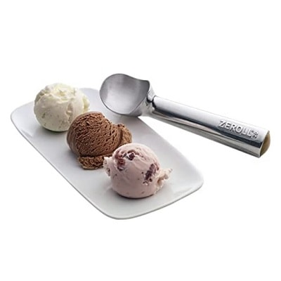Three scoops of ice cream in a bowl with a metal ice cream scoop
