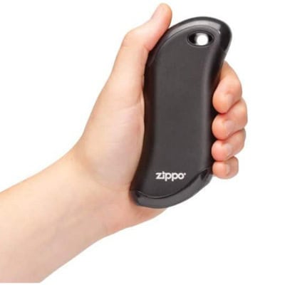 A person's hand holding a black hand warmer