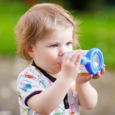 A child drinking from a blue Sippy Cup