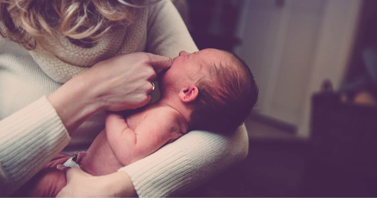 career changes after baby - a working mom holding her baby and thinking about how her job, career, and life plans changed after pregnancy