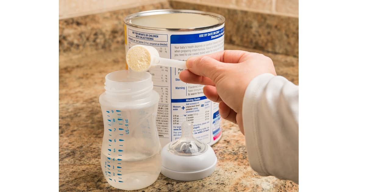 A woman making milk on a breastfeed bottle.