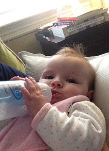 A baby drinking milk on a breastfeed bottle