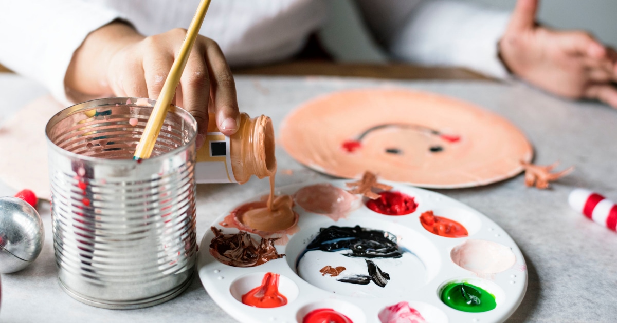 a  person pouring paint on a painter\'s palette