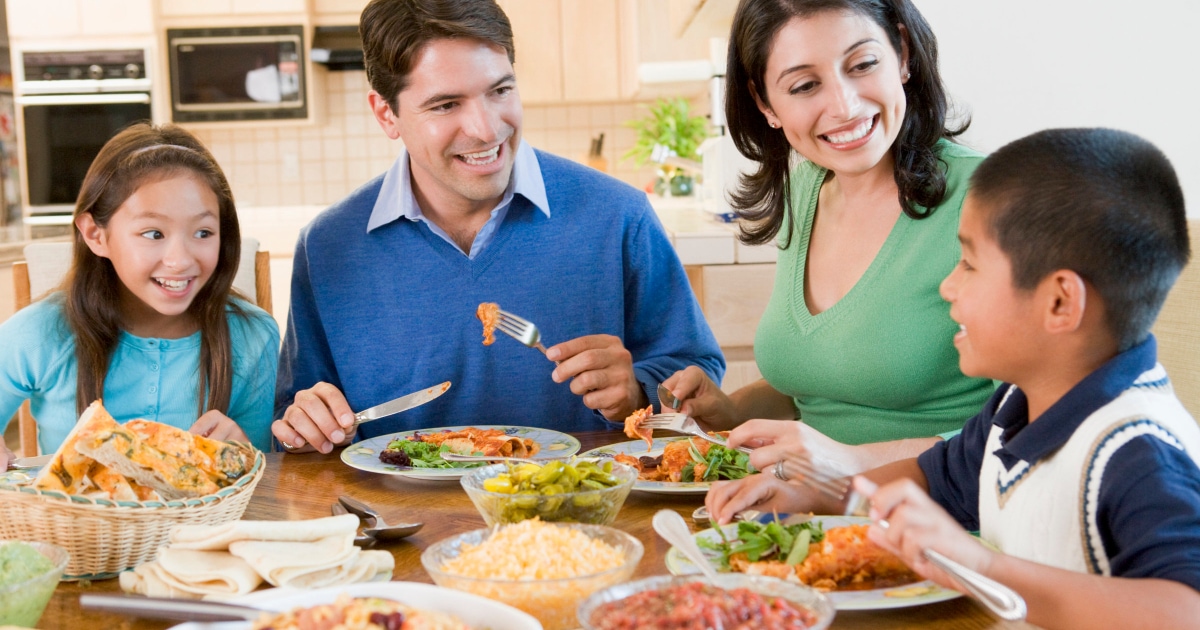 multicultural family enjoying dinner together