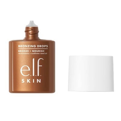 An open bottle, with white cap beside it, of e.l.f.'s SKIN bronzing drops