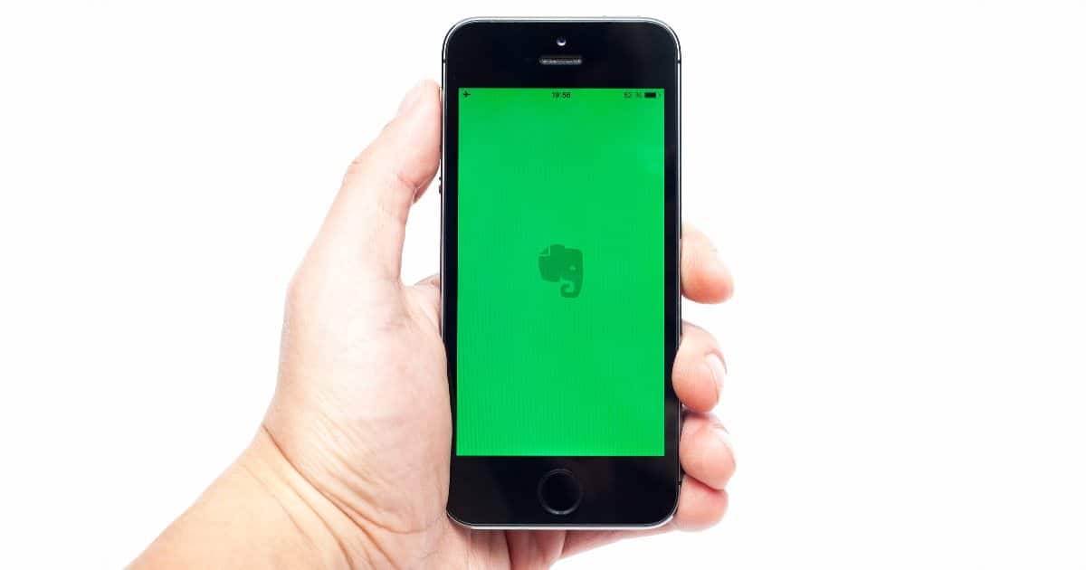 person holds phone with green background and evernote logo