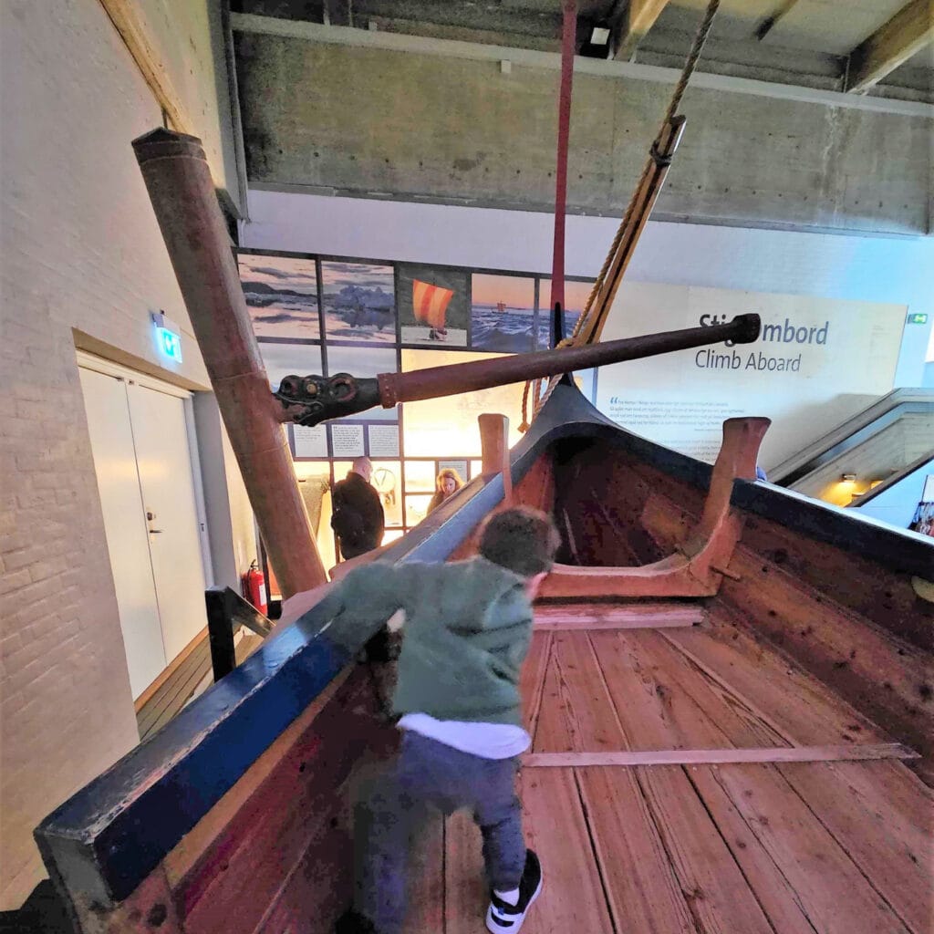 small boy plays on a Viking ship in Copenhagen
