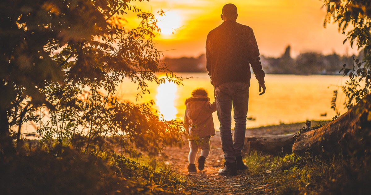 A man with his child, watching the sunset