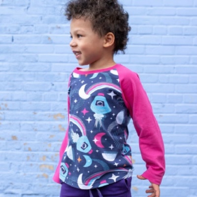 A boy wearing pink sweater with rocket print