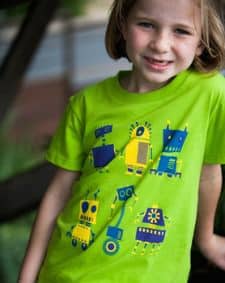 A kid wearing a Eep Op Woot\" Girls\' Robot T-Shirt.