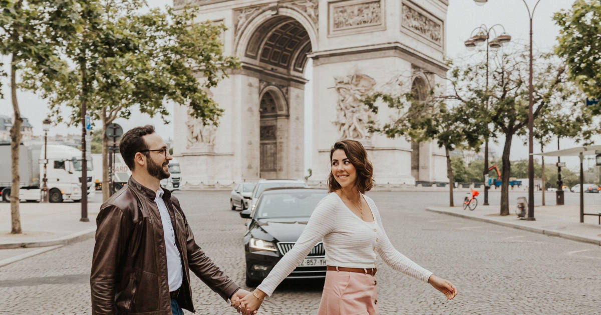 photo of man and woman walking in front of Paris landmark