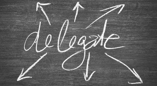 the word "delegate" is written on a blackboard in chalk, with 6 arrows going out in every direction