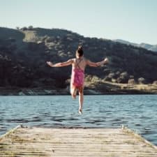 A woman who is going to jump on the beach.