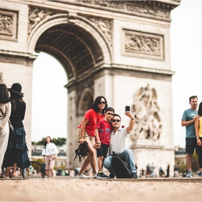 A family taking a picture in front of the Arc de Triomphe, France