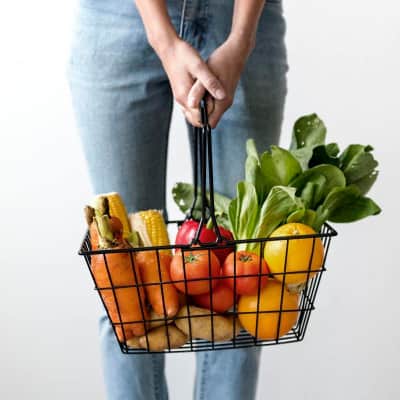 A woman holding a basket of health food options