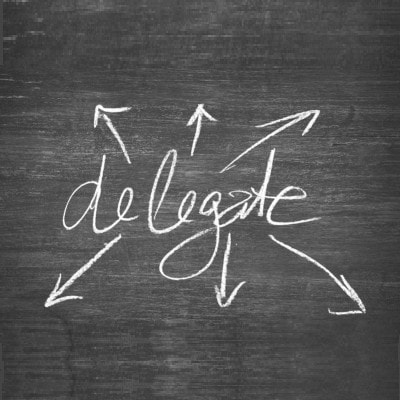 the word "delegate" is written on a blackboard in chalk, with 6 arrows going out in every direction