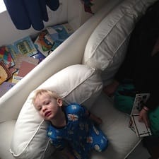 A child seated on a couch while looking up to the ceiling 