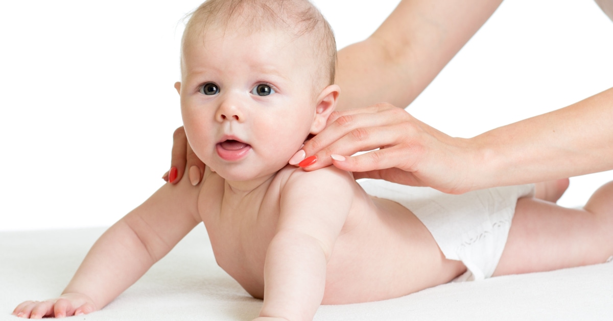 A mother massaging her baby