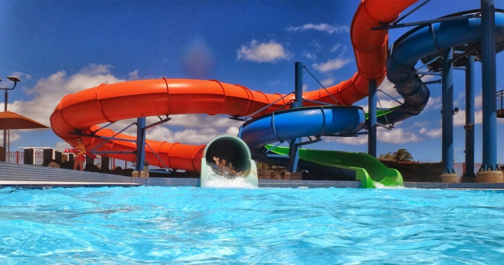 A waterpark with two people coming out of a slide