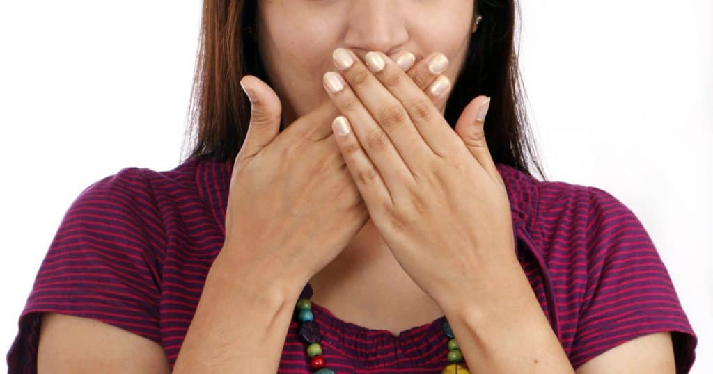 A woman covering her mouth with her hands