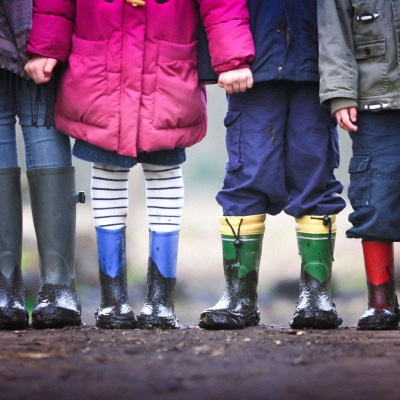 a group of kids posing for the camera wearing rainboots