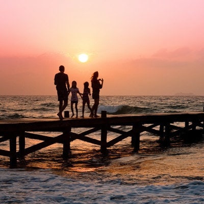 A group of people standing on a pier near the beach
