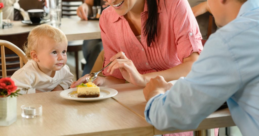family in restaurant, mom cutting piece of pie for her baby