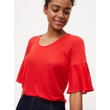 A woman wearing a Mixed Media Pleated Sleeve Tee.