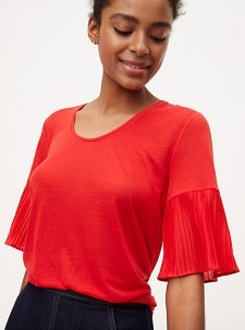 A woman wearing a Mixed Media Pleated Sleeve Tee.
